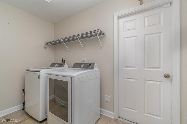 laundry room featuring light tile patterned flooring and washer and clothes dryer