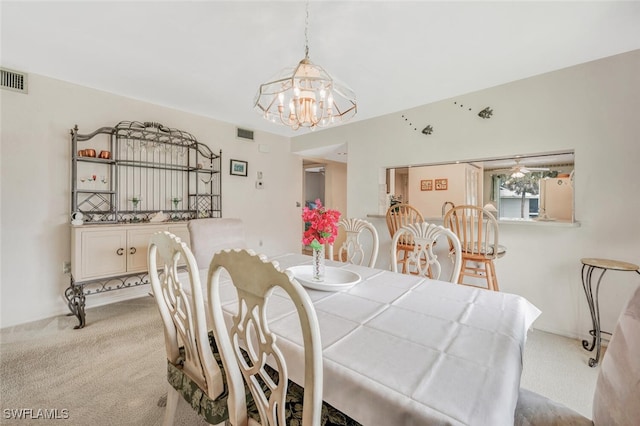 carpeted dining area featuring a chandelier