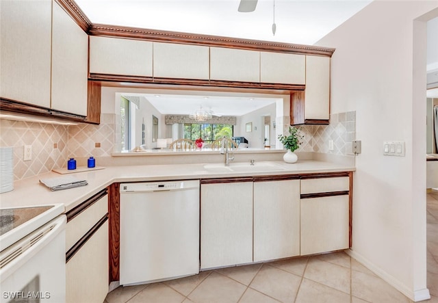 kitchen with tasteful backsplash, an inviting chandelier, sink, white dishwasher, and light tile patterned floors