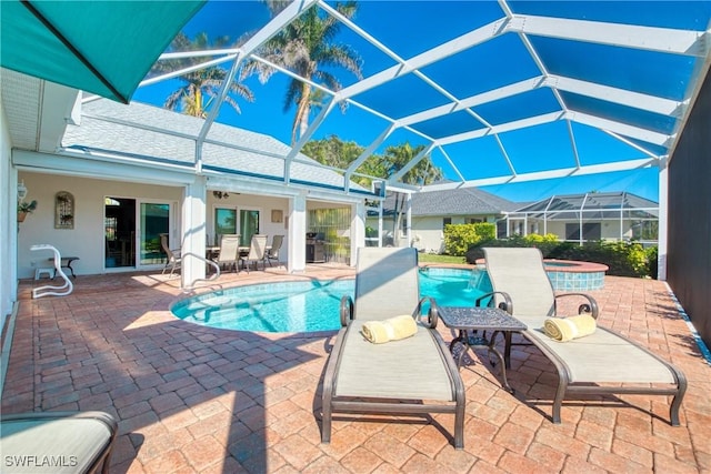 view of swimming pool featuring a hot tub, a patio area, and a lanai