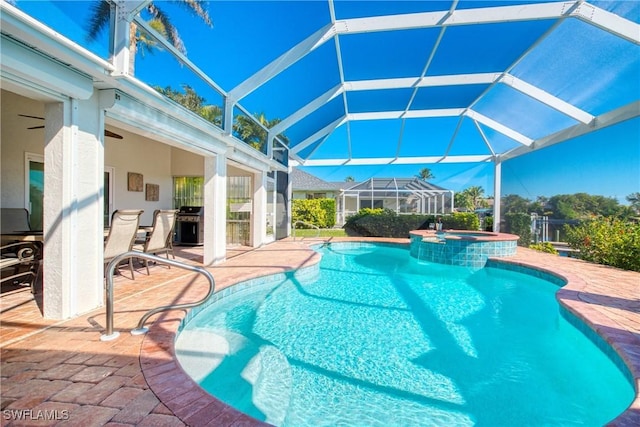 view of pool with an in ground hot tub, area for grilling, a patio, and glass enclosure