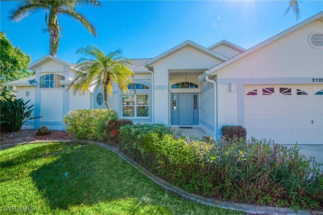 single story home featuring a garage and a front lawn