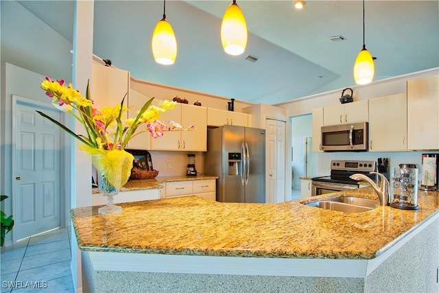 kitchen with appliances with stainless steel finishes, kitchen peninsula, sink, and hanging light fixtures