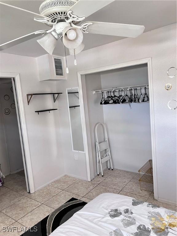 bedroom with light tile patterned floors, a closet, and ceiling fan