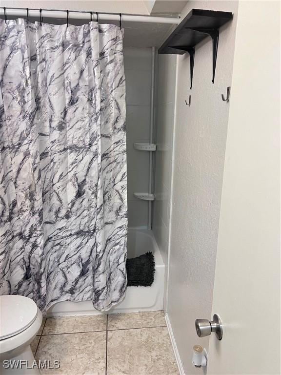 bathroom with shower / bathtub combination with curtain, tile patterned floors, and toilet