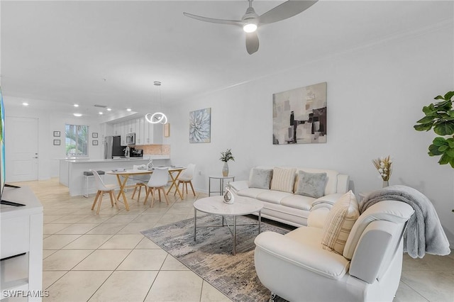 living room featuring ceiling fan, light tile patterned floors, and ornamental molding