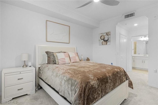 bedroom featuring ceiling fan, crown molding, light carpet, and ensuite bath