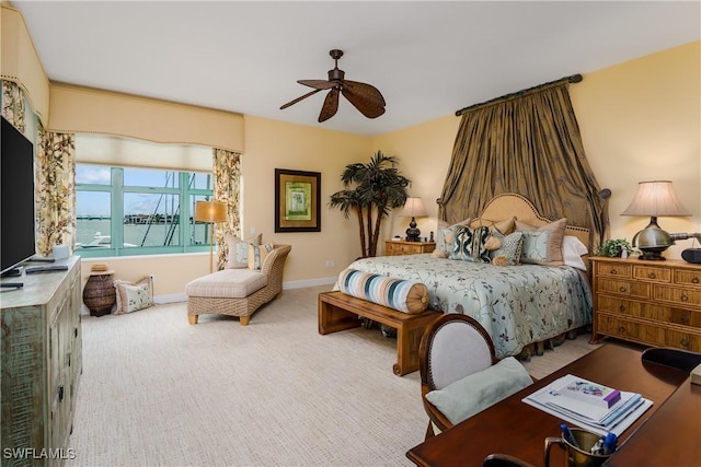 bedroom with ceiling fan, a water view, and carpet