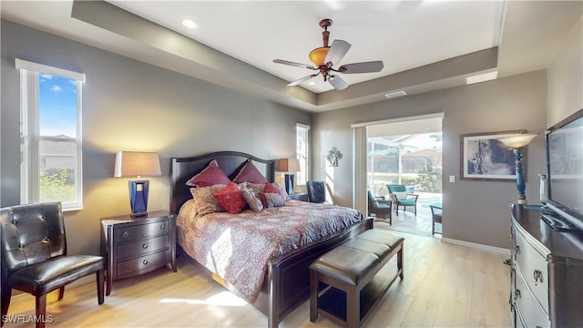 bedroom with access to outside, light wood finished floors, multiple windows, and baseboards