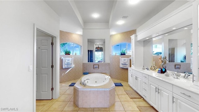 bathroom featuring tile patterned flooring, a sink, visible vents, a whirlpool tub, and double vanity