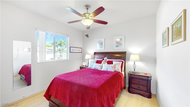 bedroom with wood finished floors, a ceiling fan, and baseboards