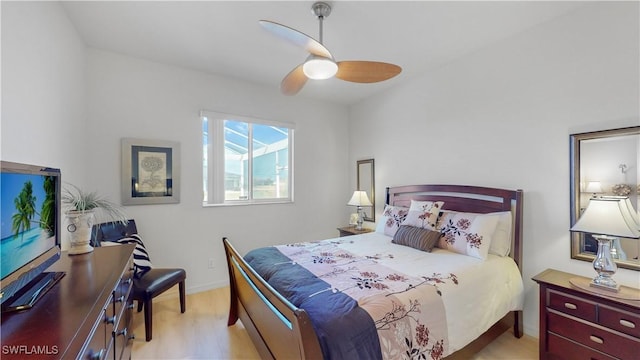 bedroom with light wood-style flooring, baseboards, and a ceiling fan