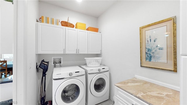 clothes washing area featuring washing machine and clothes dryer and cabinet space