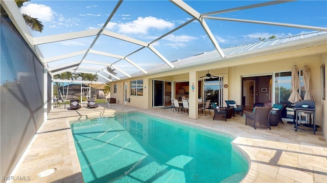 outdoor pool featuring an outdoor hangout area, a patio, glass enclosure, and a ceiling fan