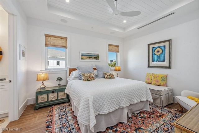 bedroom with ceiling fan, multiple windows, a tray ceiling, and wooden ceiling