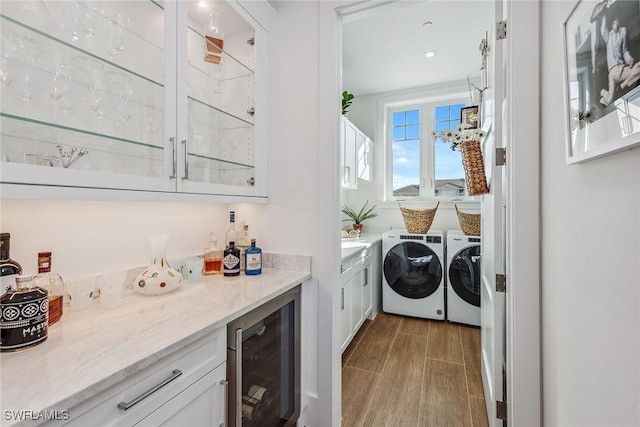 washroom with washing machine and dryer, bar area, and wine cooler