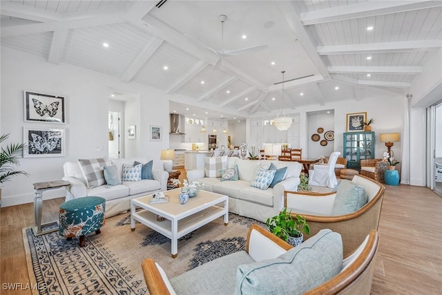 living room featuring high vaulted ceiling, beam ceiling, light hardwood / wood-style floors, and an inviting chandelier