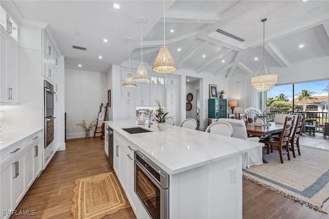 kitchen featuring an inviting chandelier, white cabinetry, a large island, and decorative light fixtures