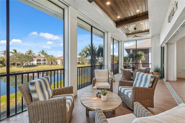 sunroom / solarium with wood ceiling, a raised ceiling, and a water view