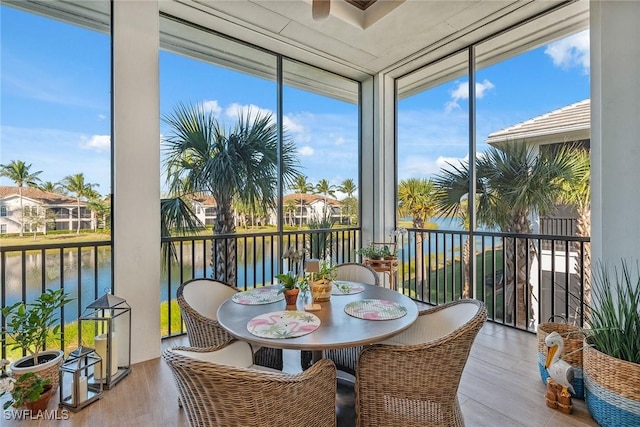 sunroom / solarium featuring a water view