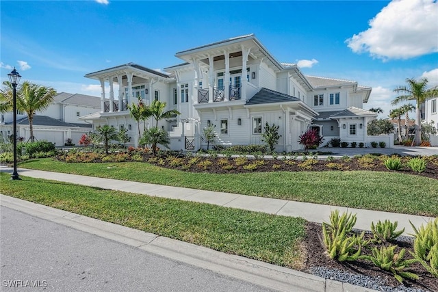 view of front of home featuring a front yard and a balcony