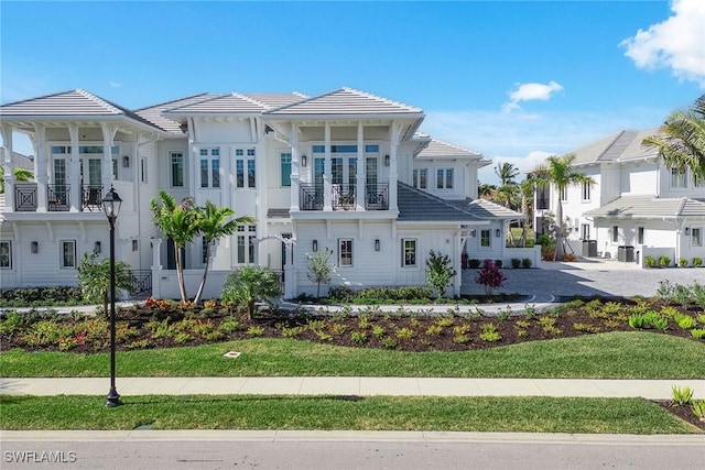 view of front facade with a balcony and a front yard