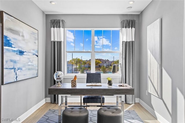 home office with light hardwood / wood-style flooring