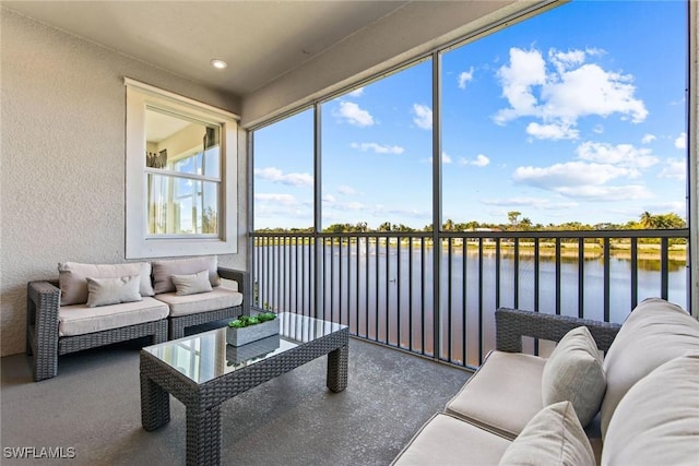 sunroom featuring a water view