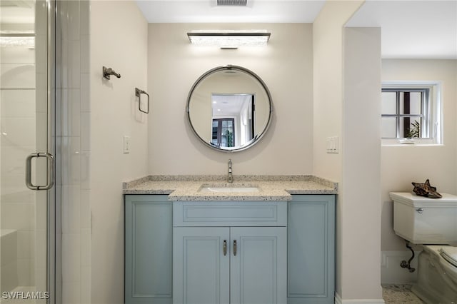 bathroom with toilet, vanity, and an enclosed shower