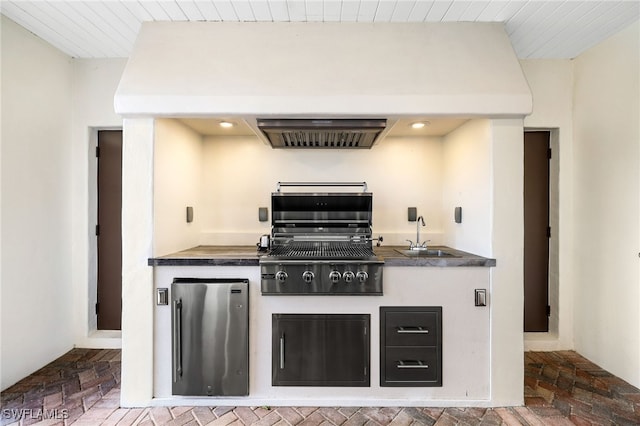 kitchen featuring sink, extractor fan, and stainless steel fridge