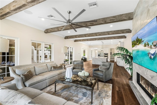 living room featuring ceiling fan, beamed ceiling, dark hardwood / wood-style floors, and a high end fireplace