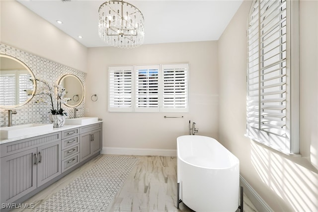 bathroom with a chandelier, a tub to relax in, and vanity