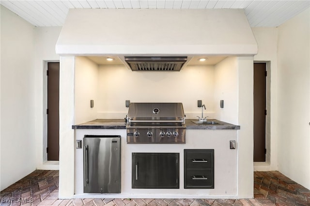 kitchen with sink, stainless steel refrigerator, and exhaust hood