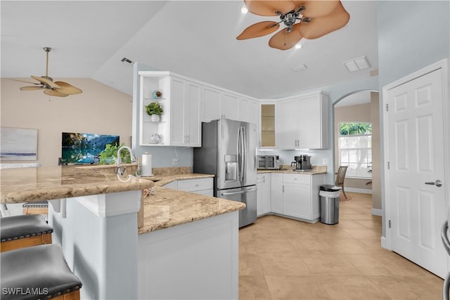 kitchen featuring kitchen peninsula, a breakfast bar area, white cabinets, light stone counters, and stainless steel fridge with ice dispenser