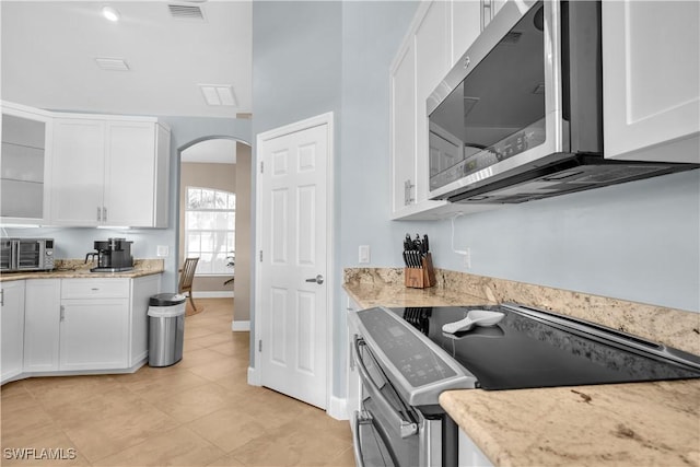 kitchen with appliances with stainless steel finishes, white cabinets, and light stone counters