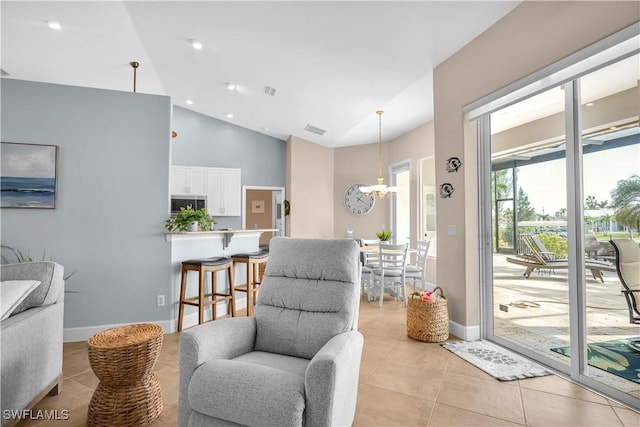 living area with an inviting chandelier, high vaulted ceiling, and light tile patterned floors