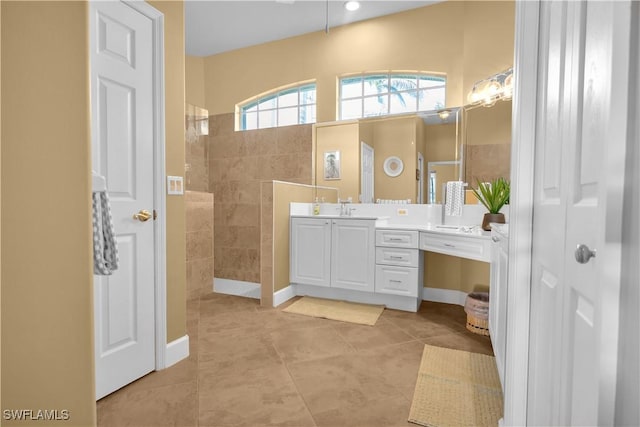 bathroom featuring vanity, tile patterned flooring, and tiled shower