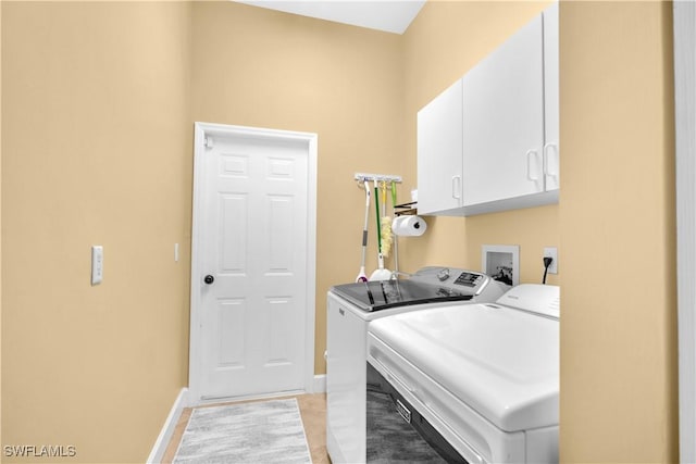 washroom with washer and clothes dryer and cabinets