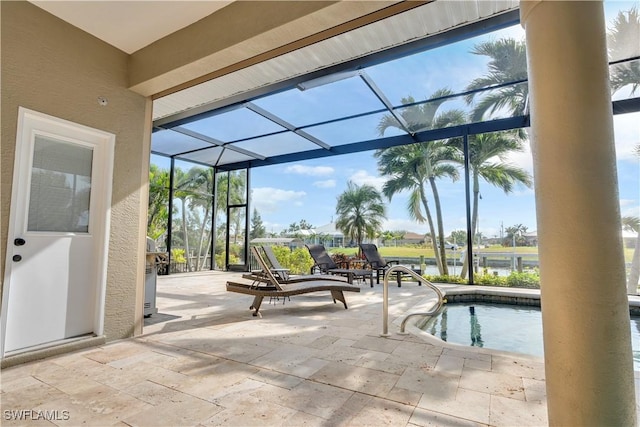 view of pool featuring a lanai, a patio area, and a water view