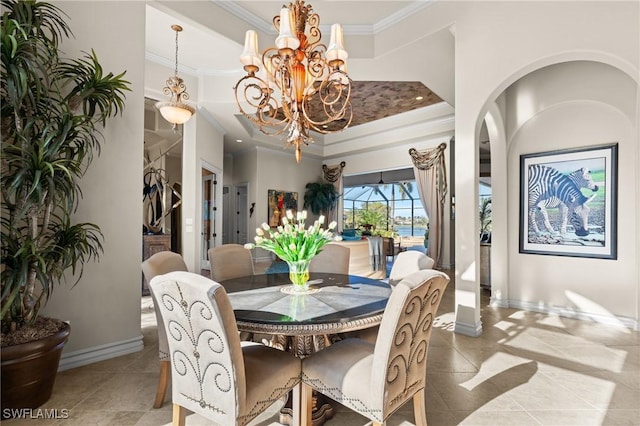 dining area featuring ornamental molding, a high ceiling, and a notable chandelier