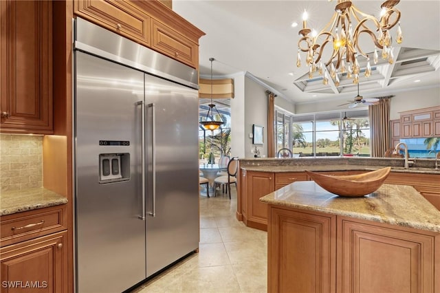 kitchen with stainless steel built in refrigerator, decorative backsplash, coffered ceiling, light tile patterned floors, and crown molding