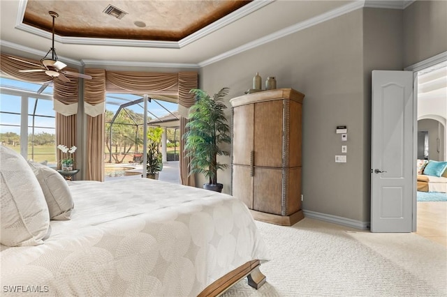 carpeted bedroom with ornamental molding, access to outside, and a tray ceiling