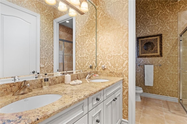 bathroom featuring tile patterned flooring, vanity, a shower with shower door, and toilet