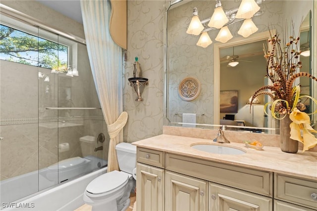 full bathroom featuring toilet, ceiling fan, vanity, and bath / shower combo with glass door