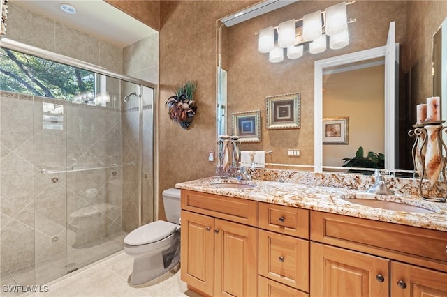 bathroom featuring toilet, vanity, tile patterned floors, and a shower with shower door