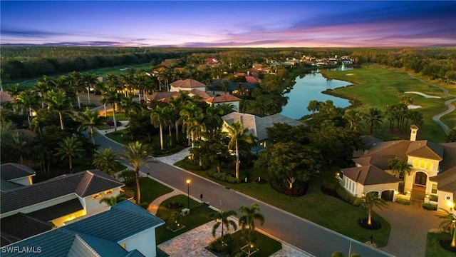 aerial view at dusk featuring a water view