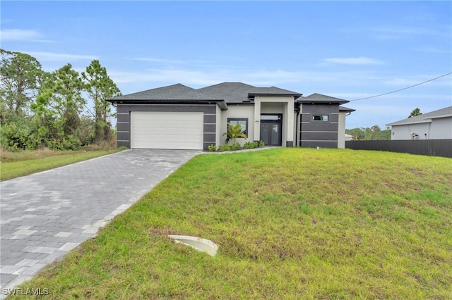 prairie-style house featuring a front lawn and a garage