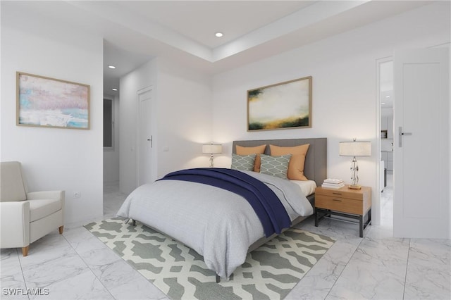 bedroom with connected bathroom and a tray ceiling