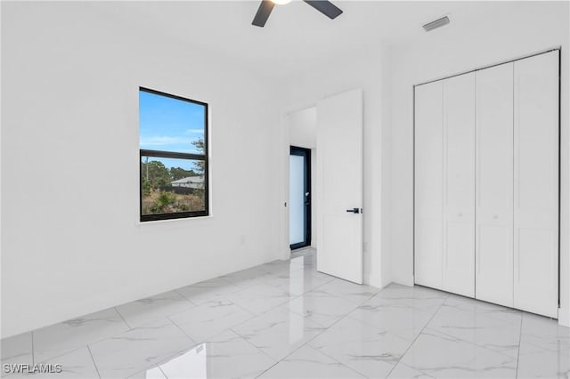 unfurnished bedroom featuring ceiling fan and a closet