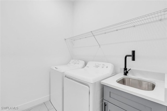 washroom with cabinets, separate washer and dryer, and sink